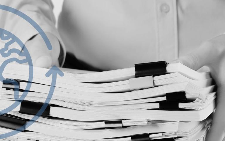 A man holds a stack of papers and there is a graphic overlay of sustainability
