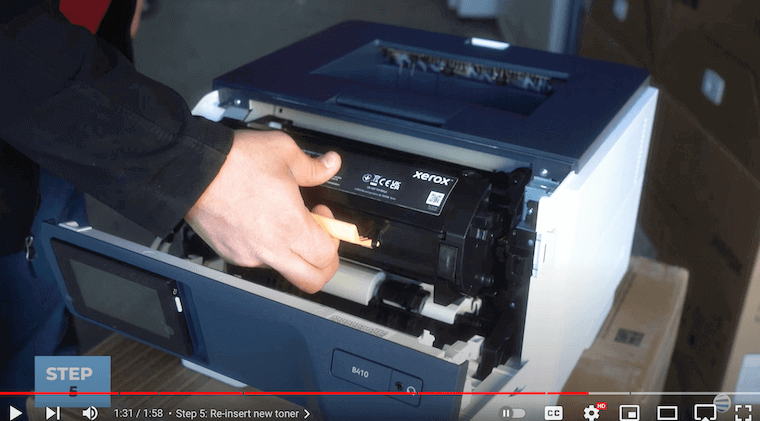 Printer technician re-inserts the toner cartridge into the Xerox B410/B415