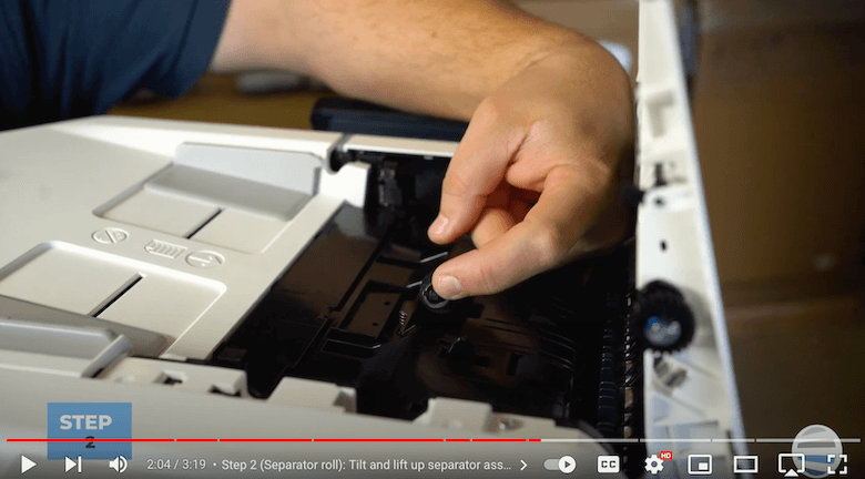 Printer technician tilts and lifts separator assembly with two fingers